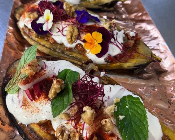 Imam bayaldi : aubergines garnies de labneh, noix et fleurs comestibles